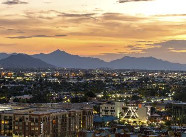 Landscape photograph in Arizona showing peaks and valleys of mountains in the background and city in the foreground